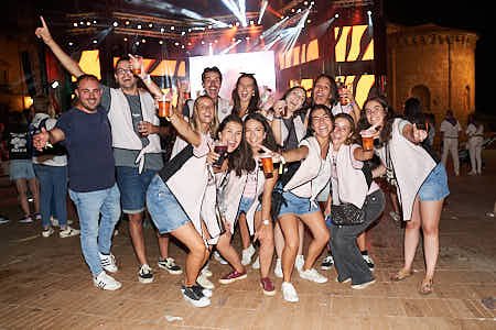 Gente celebrando un pregón de fiestas en una plaza mayor