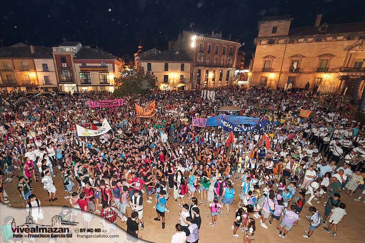 Gente celebrando un pregón de fiestas en una plaza mayor